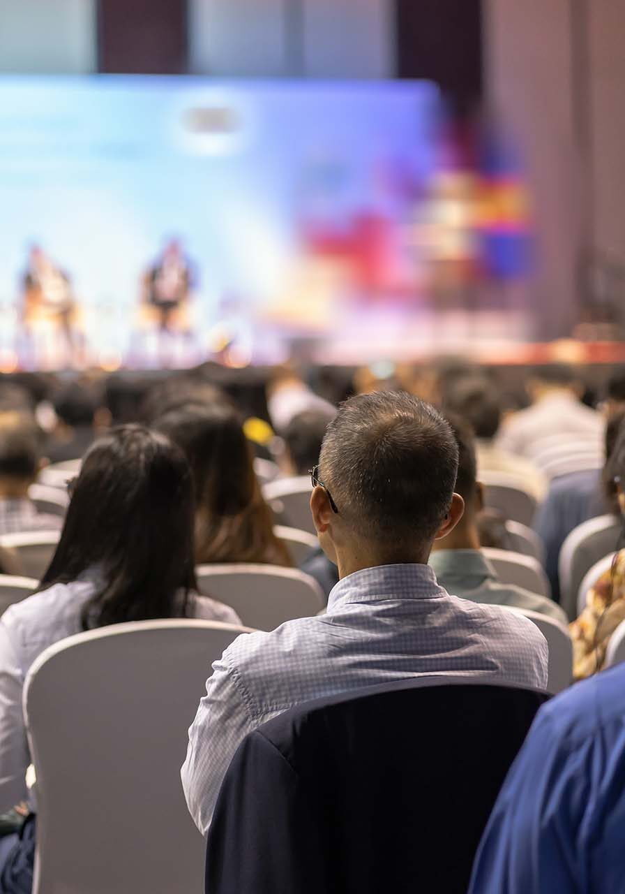 Rear view of Audience listening Speakers on the stage in the conference hall or seminar meeting, business and education about investment concept